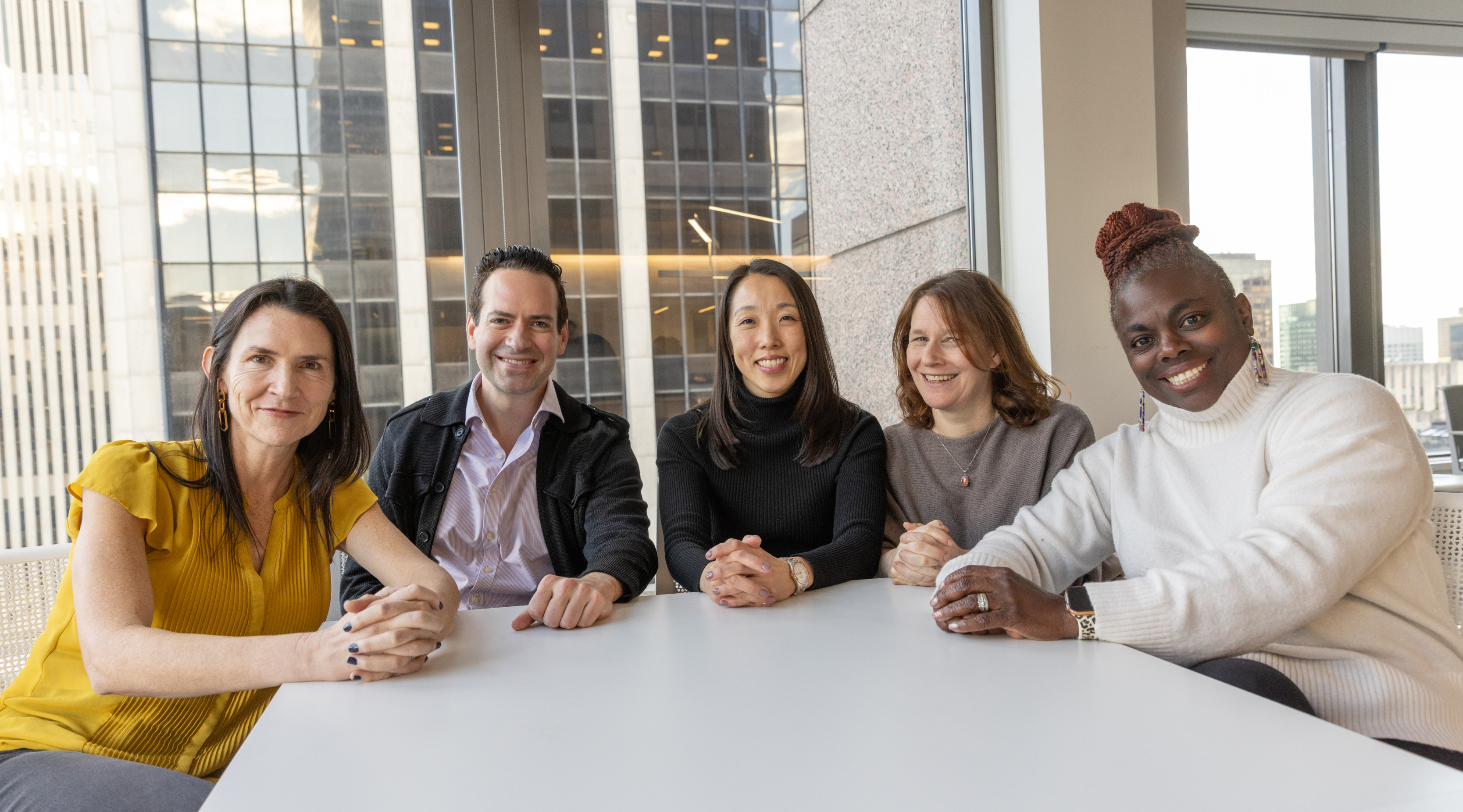 On-Ramps Partners smiling, seated at a round white table.
